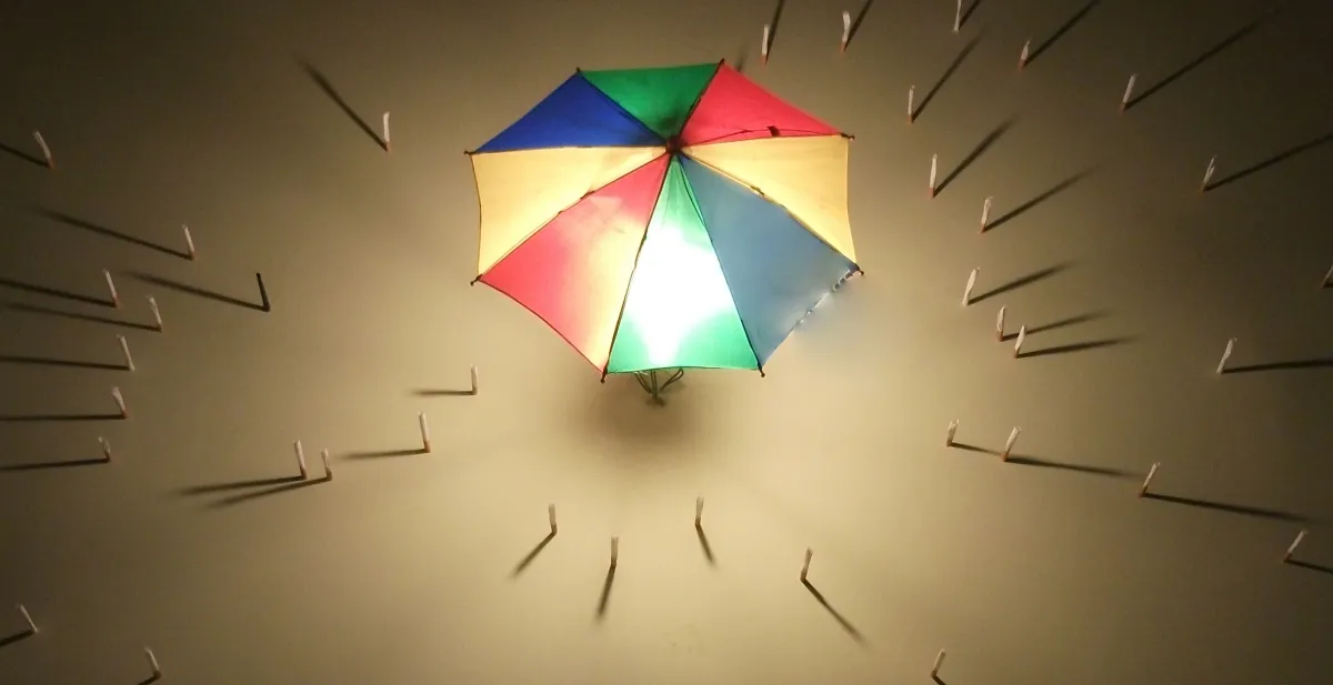 Rainbow umbrella glowing overhead with nails radiating around it